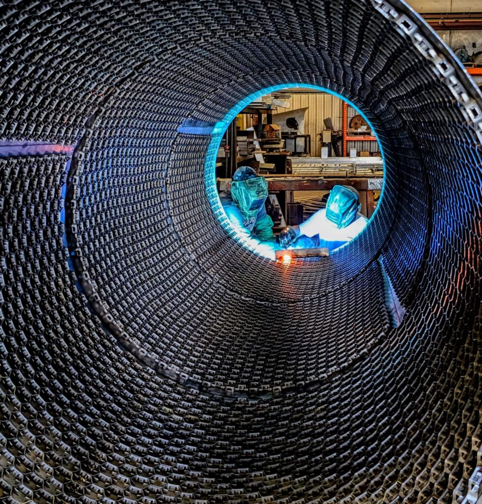 Welding hex mesh to a pressure vessel for an abrasion-resistant lining.